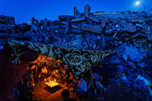 Palestinian families huddle Tuesday, May 25th 2021, during a candlelight vigil, which condemned the 