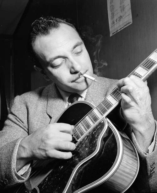 Django Reinhardt playing guitar despite only having two fully-functioning fingers on his left hand. 