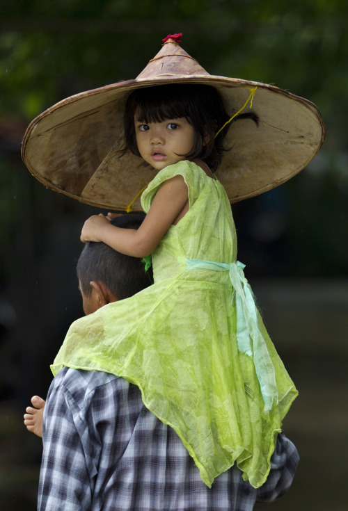 A child is carried by an adult in Khanaung Chaung Wa village, southeast of Yangon, Myanmar on June 5