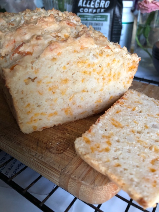 A partially sliced loaf of quick bread on a cutting board
