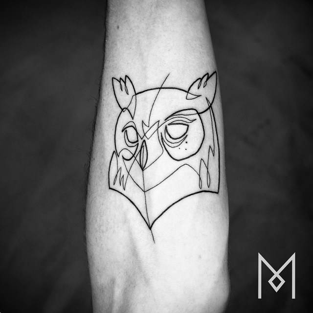 Tatuaje de la cabeza de un búho utilizando una sola línea, situado en el antebrazo. Artista tatuador: Mo Ganji