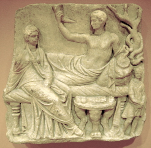 lionofchaeronea:Ancient Roman grave relief, depicting the deceased man and his wife as guests at a f