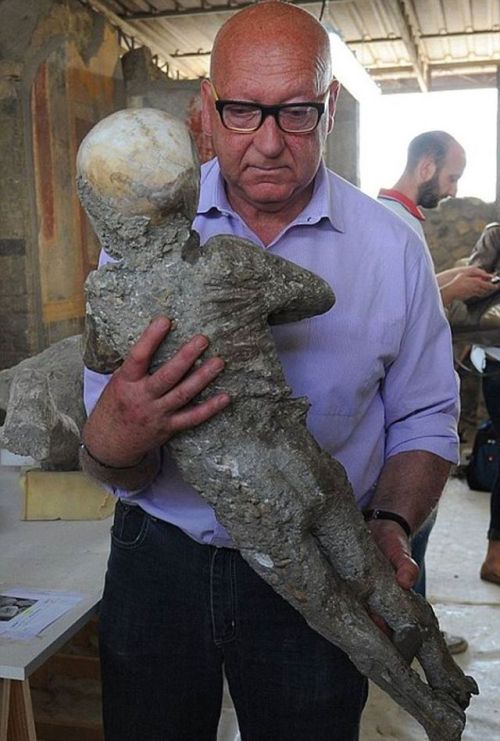 classicsftw:museum-of-artifacts:A restorer carries the plaster cast of a child from Pompeii that per