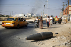 fotojournalismus:  Palestinians look at an unexploded Israeli shell that landed on the main road outside the town of Deir Al-Balah in the central Gaza Strip on August 1, 2014. (Finbarr O’Reilly/Reuters) 