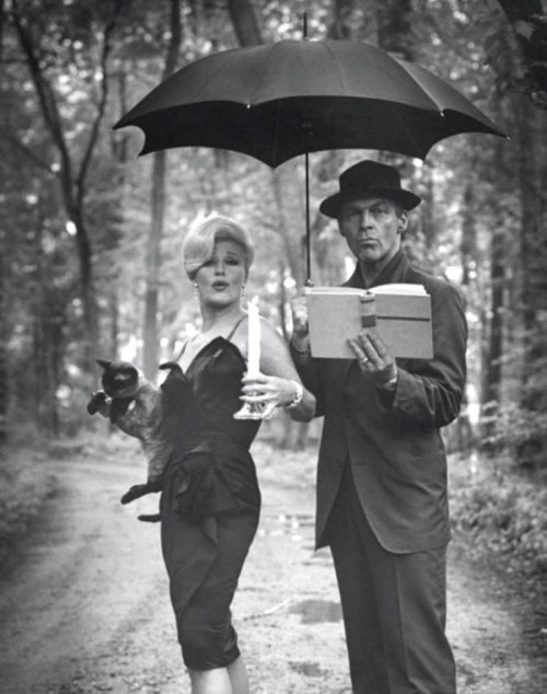 Actress Ginger Rogers and her actor husband William Marshall reading by candlelight, June 1961. Phot