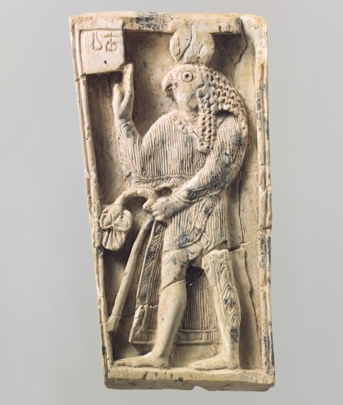 Ivory furniture plaque from Assyria, carved with a falcon-headed figure in relief.  Artist unknown; 