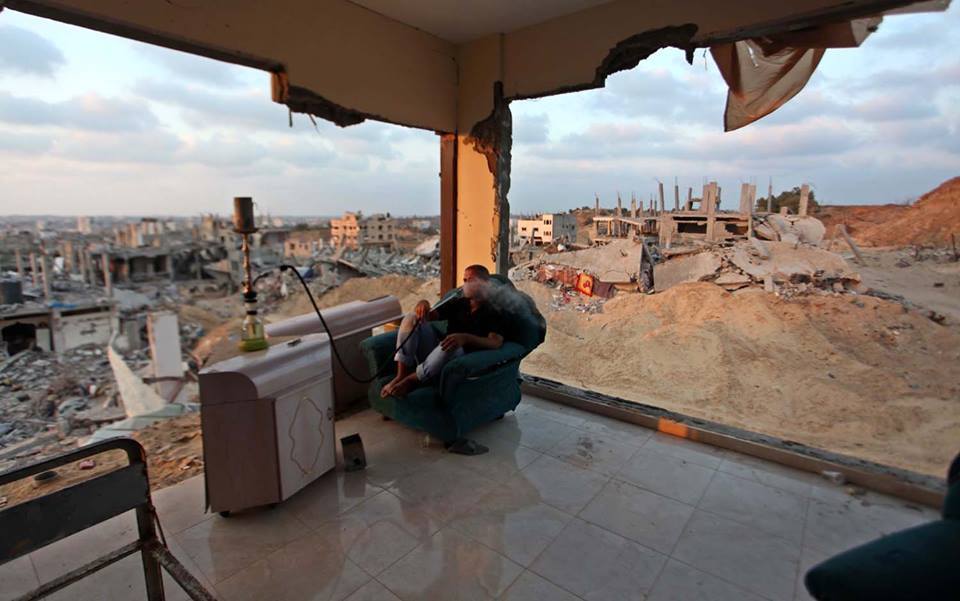 monabbasheer:  A Palestinian man smoke water pipe in destroyed houses after returning