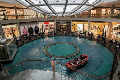 A couple sit in a gondola rowing through a water feature at the Marina Bay Sands shopping centre in 