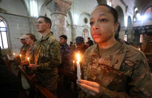 US Soldiers attend a Christmas Eve service for Iraqi Christians at the St. John’s church, Bakh