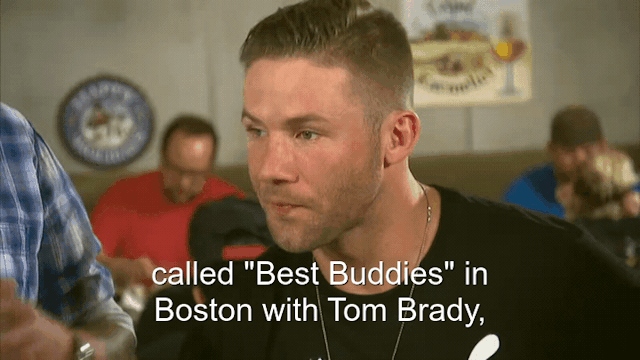 62% sure it's Julian Edelman talking on a cell phone. Caption: called "Best Buddies" in Boston with Tom Brady,