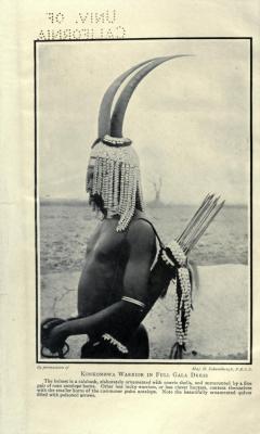 The-Two-Germanys:  Konkombwa Warrior In Full Gala Dress.a Camera Actress In The Wilds