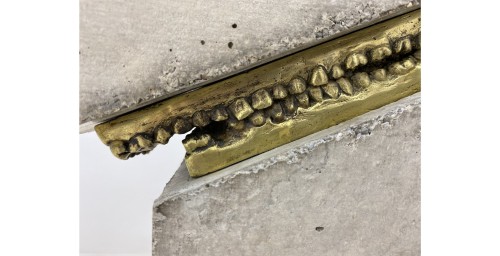 magz:
“mosertone:
“Yoan Capote created this installation, called “Stress”. The installation has teeth made from bronze supporting large slabs of concrete
”
ID: Huge blocks of concrete, diagonally cut and slanted to the side.
The bronze teeth...