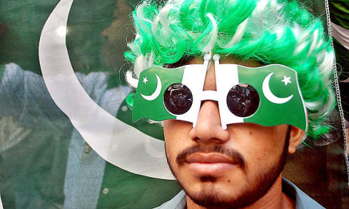 A youngster wearing cap and glasses to celebrate the Independence Day of Pakistan. Credits: APP