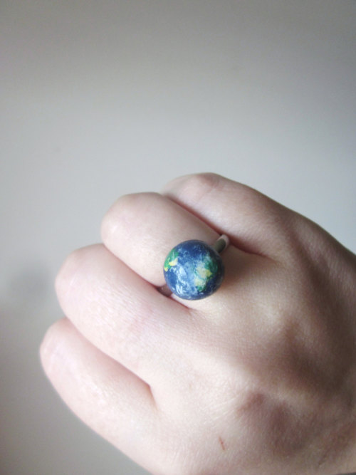 wickedclothes:  Planet Rings Bring outer space to the palm of your hand. Or to your fingers. Each of these rings resemble a piece of space. Featuring Neptune, Earth, the Sun, and a deep blue-colored galaxy, each of these rings are adjustable to fit your