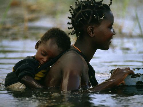 everysinglecountry: Mbukushu mother and child traverse the Okavango River, Botswana photograph by F