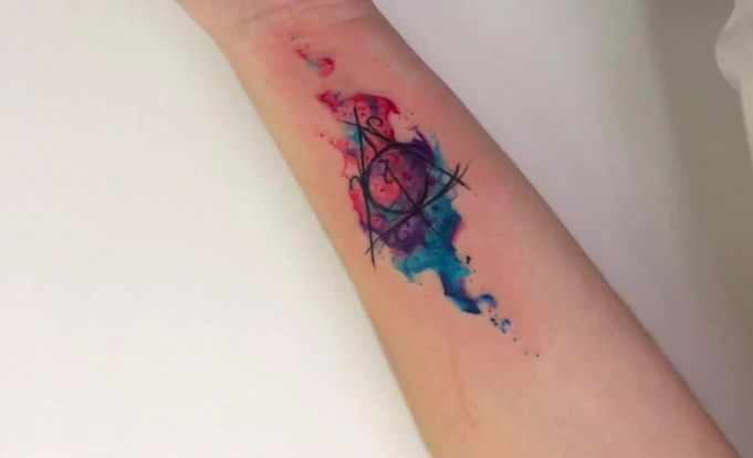 Nice Deathly Hallows Watercolor Tattoo On Bicep By Blue Chara