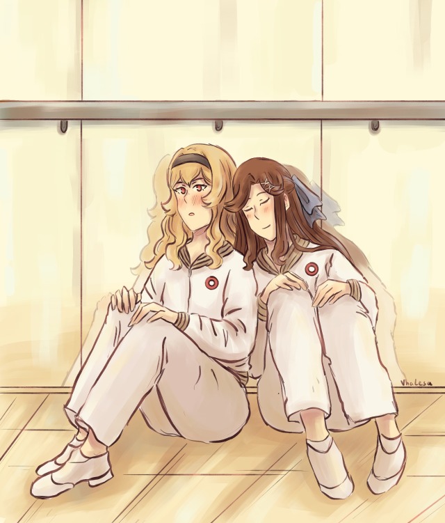 Maya and Claudine taking a little break from training. They sit together, Maya has her eyes closed and leans her head onto Claudine's shoulder.