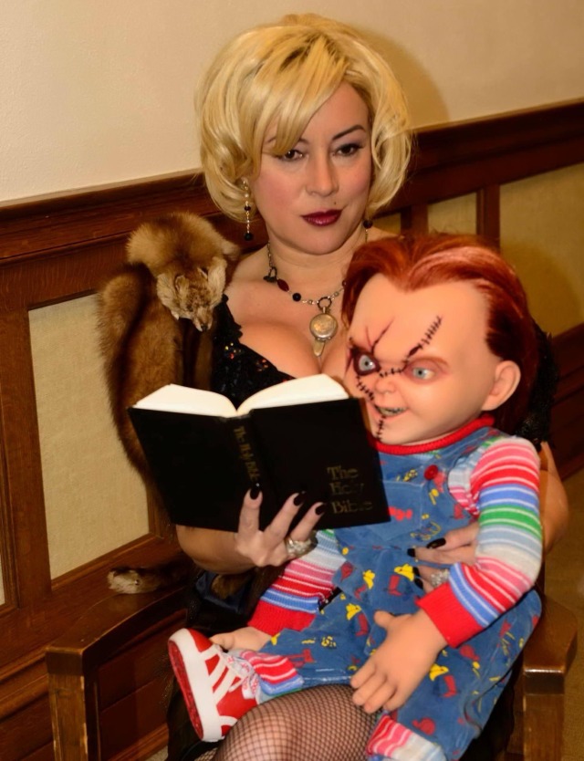 Jennifer Tilly as Tiffany Valentine reads the Bible with Chucky in a promotional photoshoot for Curse of Chucky, 2013.