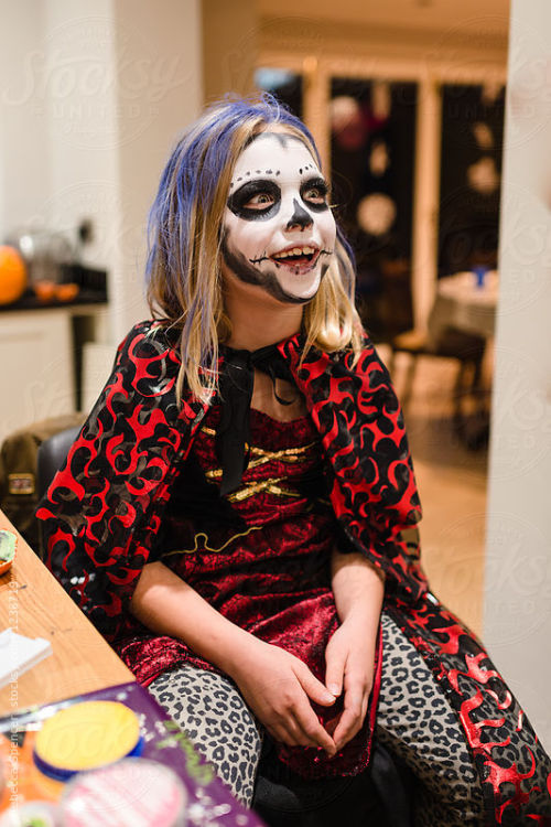 Grinning beautiful girl in her day of the dead Halloween make up By RebeccaSpencerAvailable to licen