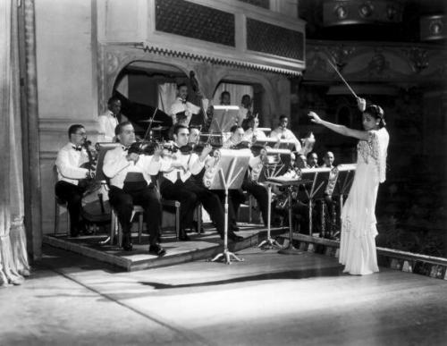 Valaida Snow, renowned musician and composer (1904-1956), conducting an orchestra in London in Octob