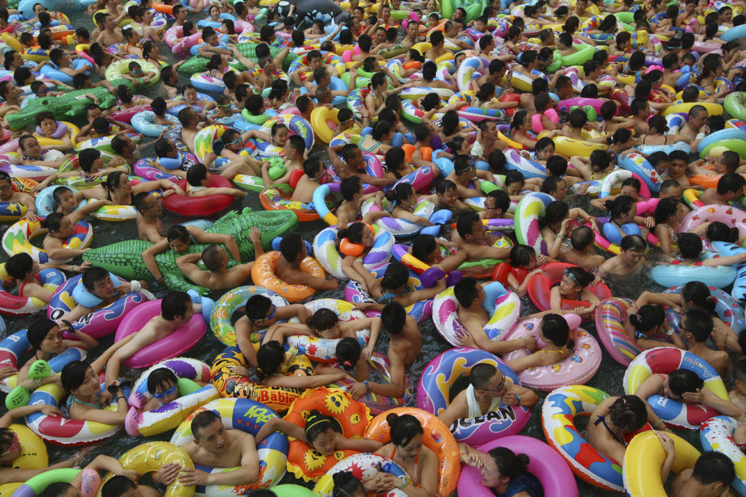 Photos of the Year: Visitors crowd an artificial wave pool at a tourist resort in China (Photo by China Daily/Reuters via Yahoo News)