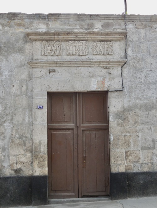 Las Puertas de Arequipa XII - Puerta marrón en un muro de piedra con un dintel tallado, 2017.