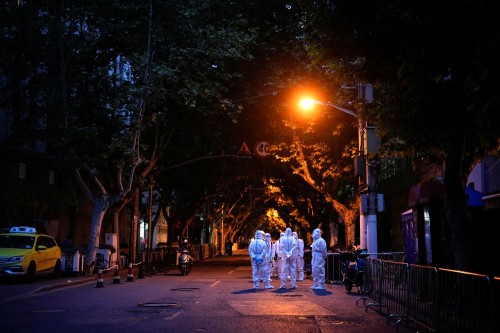 From The End of Shanghai’s Two-Month COVID Lockdown, one of 22 photos. Workers in protective suits s