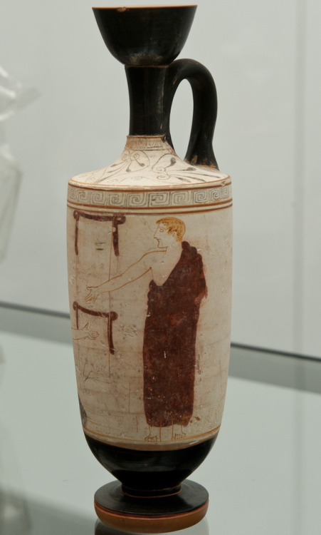 A draped youth is visiting a funerary stele. Attic white ground red figured lekythos. Attributed to 