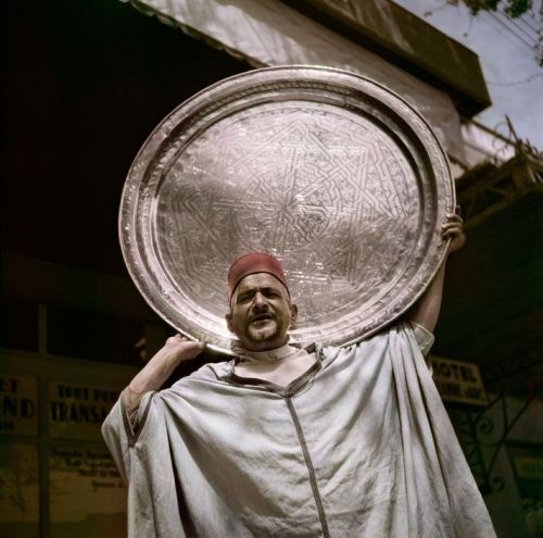 1001arabianights:   Man holding a hand-beaten copper tray , MOROCCO 1949.