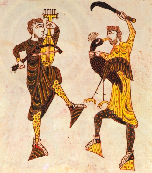 inacom:Two men dancing, one with a violin type instrument, the other holding a bird and brandishing 
