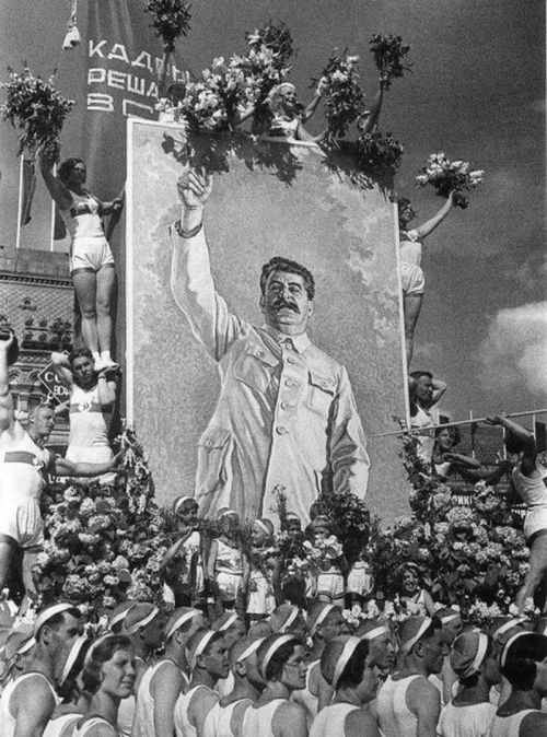 sovietreality: Soviet athletes standing at attention white holding a portrait of Joseph Stalin (late