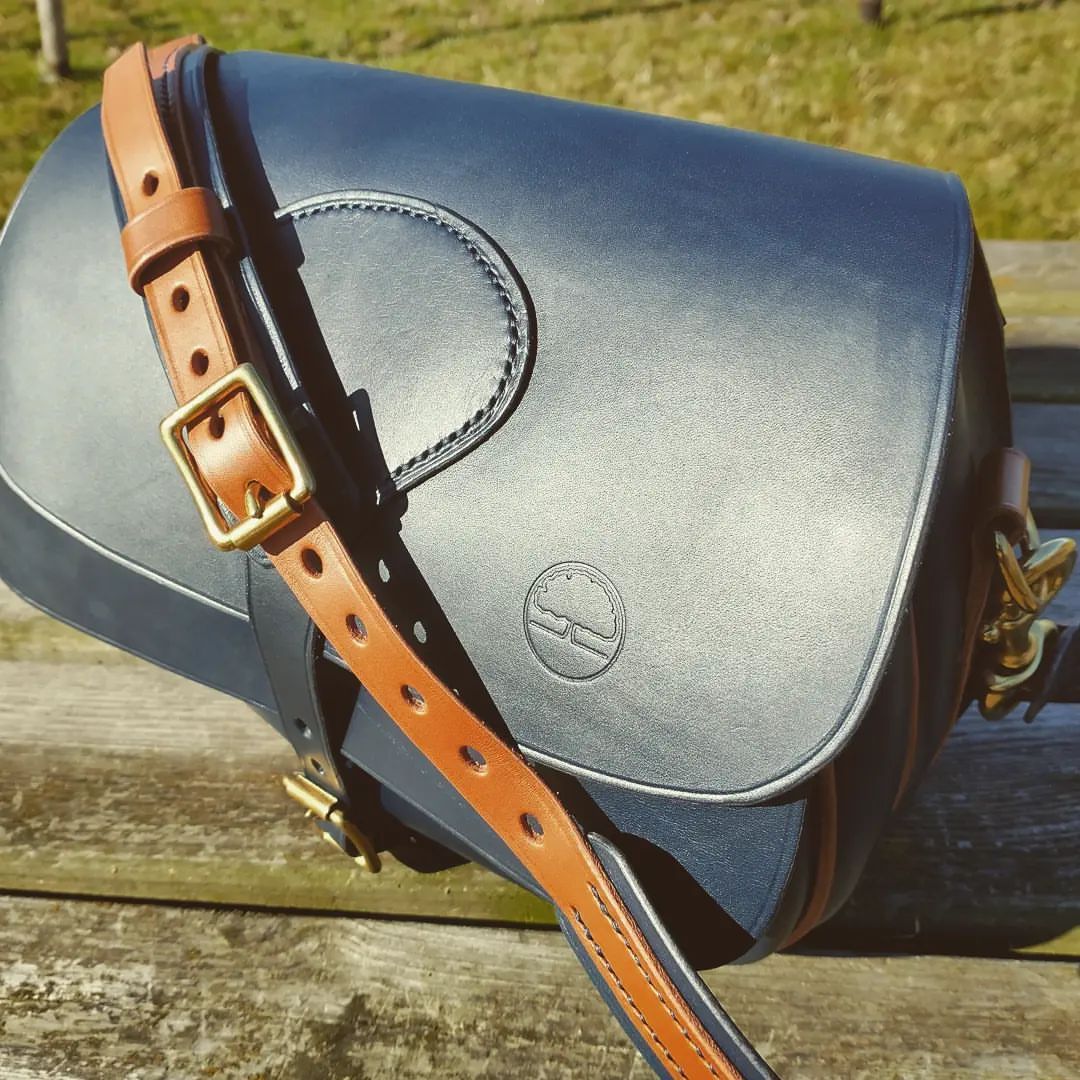 <p>Cartridge bag<br/>
I made something different the other day. A handbag based on a cartridge design. I must say that I do rather like it.<br/>
Leather is @metropolitanleather.est1919 Lamport 2mm Blue and 1.5mm dark tan piping.<br/>
Fittings are from @abbeyenglandltd all in brass.<br/>
Thread is Artisan leather braided polyester.<br/>
All hand stitched(which took bl**y ages) using a round hole stitching punch on the piped seams and diamond stitch marks on the exposed seams.<br/>
Two pockets give you plenty of room for carrying all your useful bits and pieces whilst looking good.<br/>
For more handmade leather goods made in England visit <a href="http://www.oaksidesaddlery.co.uk" target="_blank">www.oaksidesaddlery.co.uk</a><br/>
#oaksidesaddlery #madebyhand #madeinengland #handcrafted #handstitched #handmadeleather #handmadeleathergoods #handbag #cartridgebag #leatherbag <br/>
<a href="https://www.instagram.com/p/CU10TGIjmnE/?utm_medium=tumblr" target="_blank">https://www.instagram.com/p/CU10TGIjmnE/?utm_medium=tumblr</a></p>