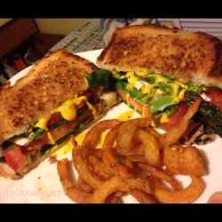 fatassvegan:  So first I fried up some asparagus in olive oil and oregano. Then I made this sandwich: spinach, asparagus, tomato, more spinach, asparagus, tomato, and vegan cheese. Then I grilled the sandwich in earth balance butter and added mustard