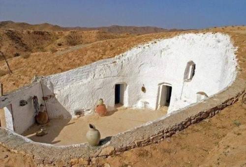 architecturealliance:“A traditional medieval cave house with a courtyard found in the desert of Libya.”