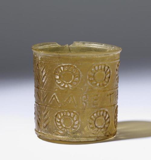 Ancient Roman glass cup, with an inscription in Greek, ΛΑΒΕ ΤΗΝ ΝΙΚΗΝ (”Seize the victory”), surroun