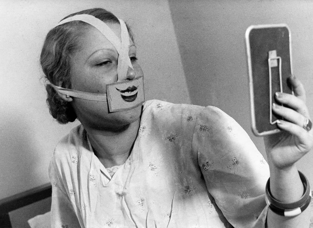 “In the Smile School of Budapest, a woman watching herself in the mirror with a grim bound on her face.” Het Leven, 1937.
From The City of Smile