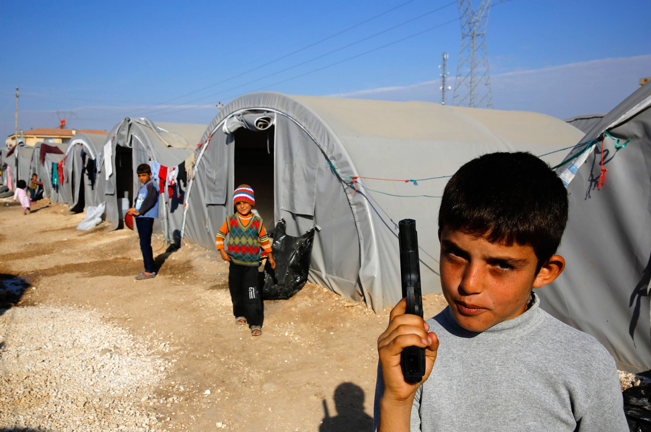 unrar:A young Kurdish refugee from Kobani holds a toy pistol at a Kurdish refugee