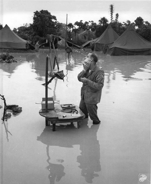 warhistoryonline:US Marine Staff Sergeant A S. Barnacle shaving in his camp on Okinawa, Japan, ignor
