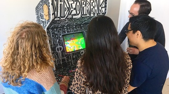 Four people gathered around Videofreak, photo via Allen Riley