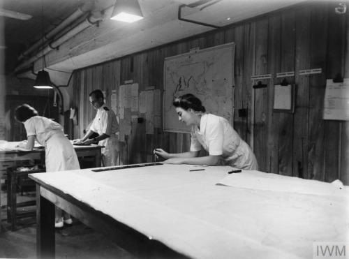 Wren M. Cooper at work plotting out the course of a ship on a chartin a Ceylon plotting room (1943).