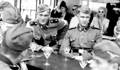 German SS men of the 1st SS Panzer Division Leibstandarte SS Adolf Hitler (LSSAH)  have drinks at an