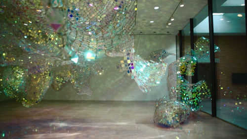 Soo Sunny Park (b. Seoul, Korea) - Unwoven Light at Rice University’s Rice Gallery in Houston, Texas. Composed of 37 individual sculptural units, the installation uses iridescent plexi-glass embedded in pieces of a chain link fence to cast shimmering,