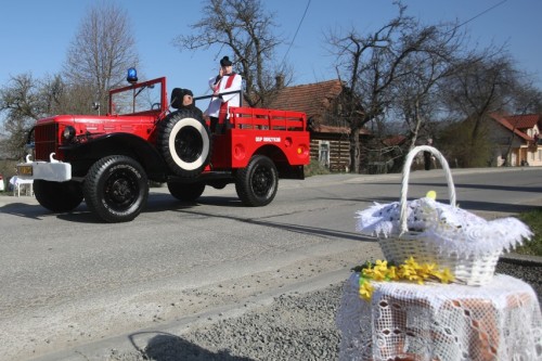 Polish priest blessing easter food and the village streets from an antique firefighting vehicle. Odr