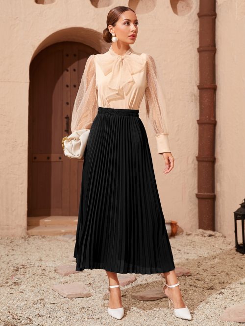 Super stylish pleated skirt worn with a very feminine bow blouse