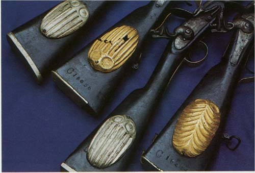 Antique muskets decorated with gold or silver Akan buttstock ornaments.  The Akan are a people nativ