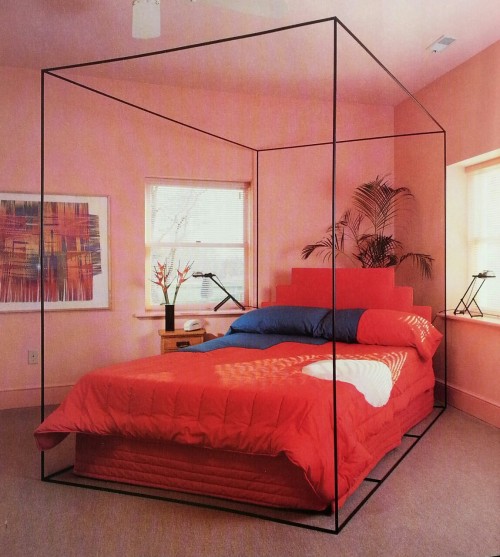 80sdeco: Salmon walls, blue, red and white quilted comforter, 80s deco stepped headboard, cube four 