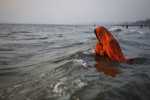 o-g-steve:awkwardsituationist:indian hindu devotees offer prayers to the sun in the arabian sea duri