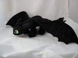 spaceplush:  Toothless is made entirely from minky fabric. He has embroidered details and suedecloth claws. He’s approximately 24 inches long with a 32 inch wingspan. He was really hard to photograph since he’s so big! He’s very soft and his feet