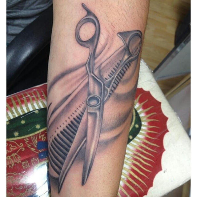 Premium Photo | Comb and a pair of scissors man is holdind in this tattooed  hand