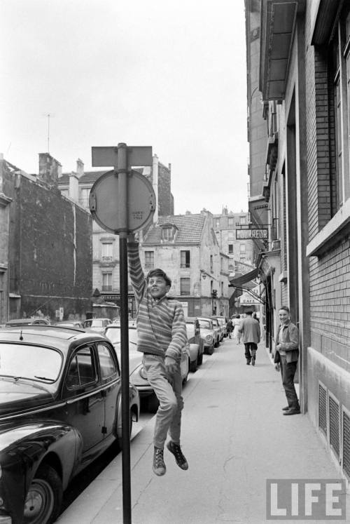 French boys taking part in the international sport of jumping high to slap a sign(Alfred Eisenstaedt
